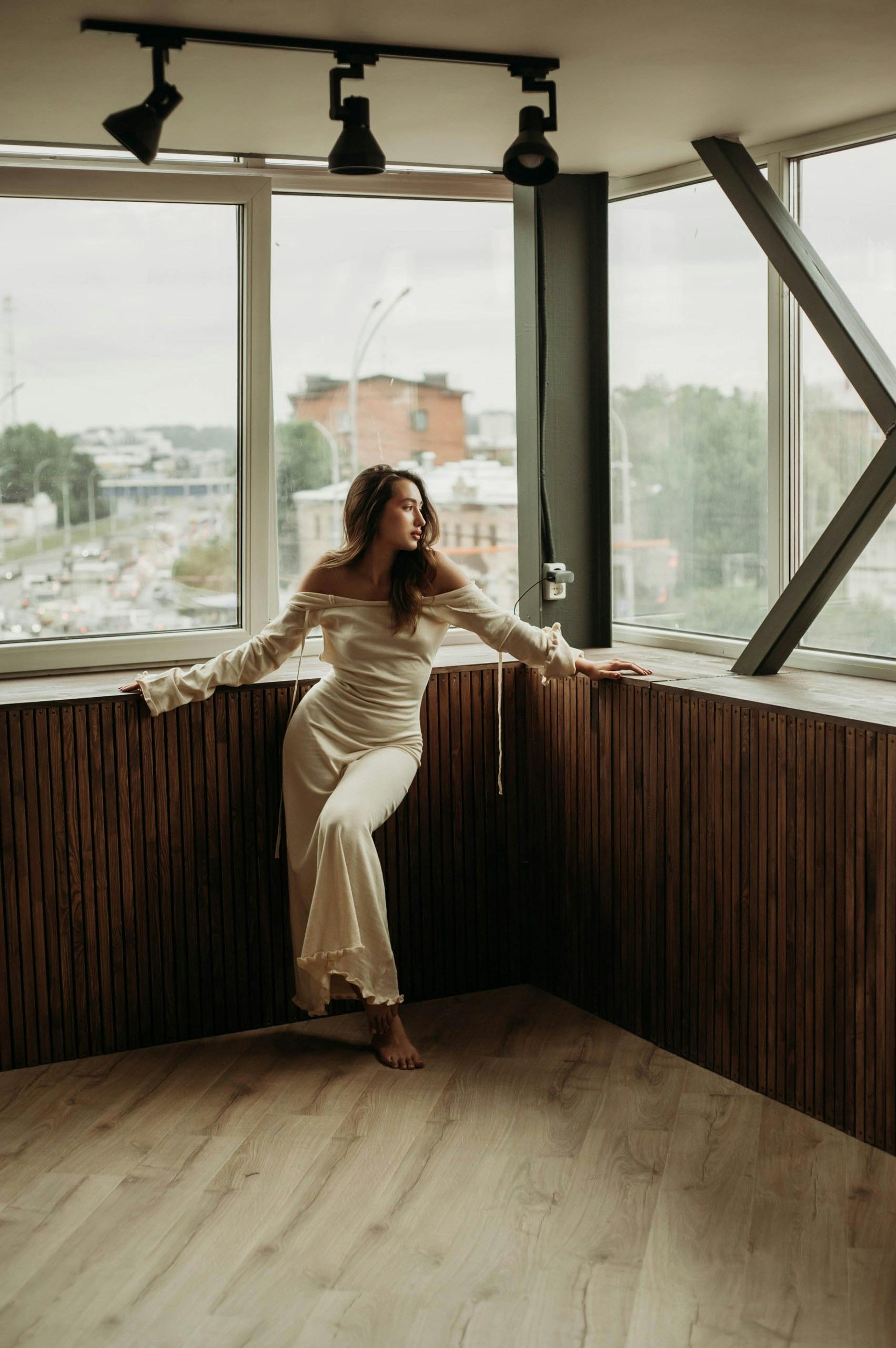 woman in white dress standing in corner of dance studio