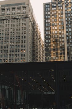 温暖的黄昏光芒映衬着现代摩天大楼的迷人景色，凸显出城市建筑的魅力