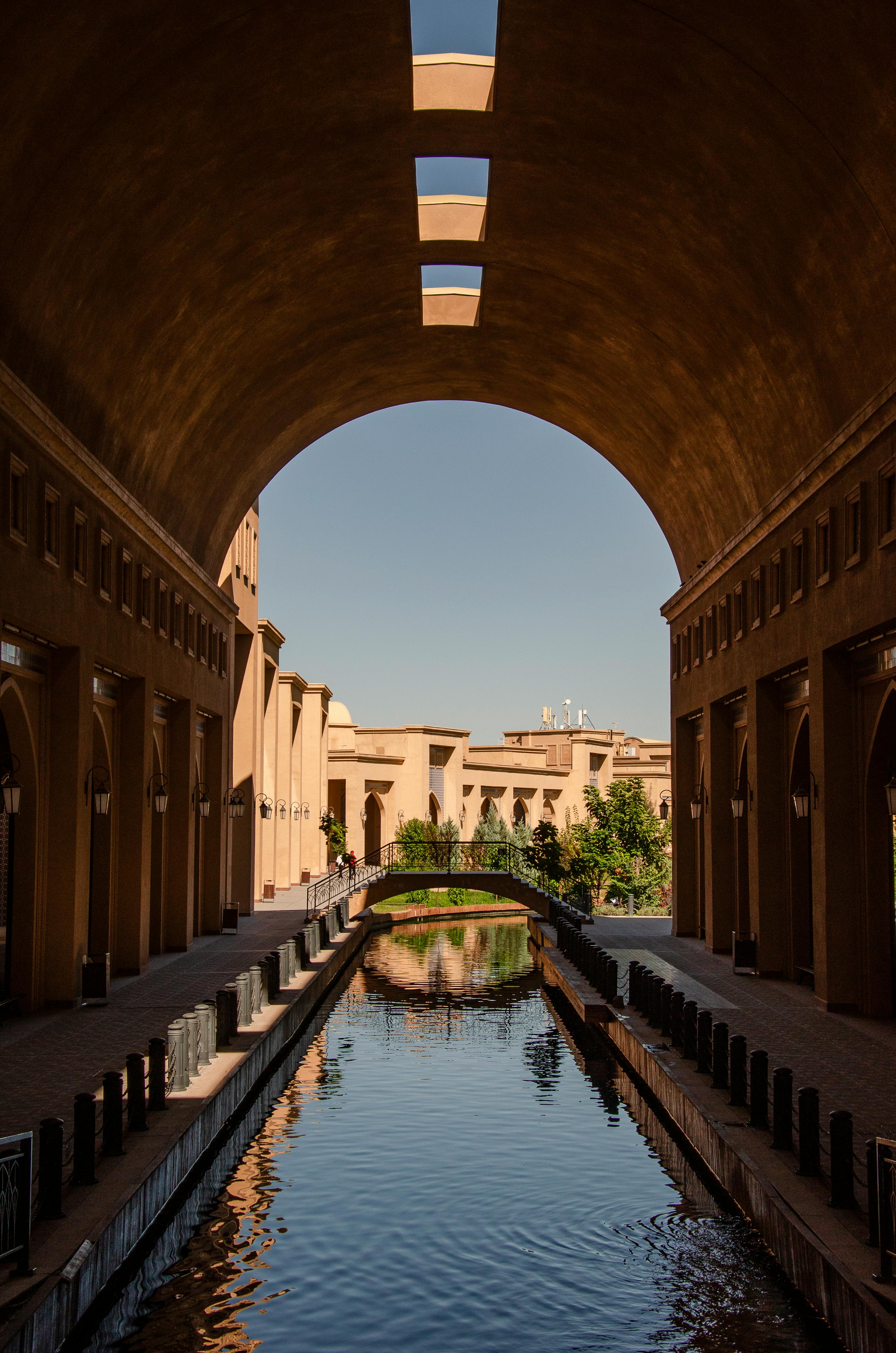 Beautiful archway leading to a canal in Turkestan, Kazakhstan, reflecting historic architecture.