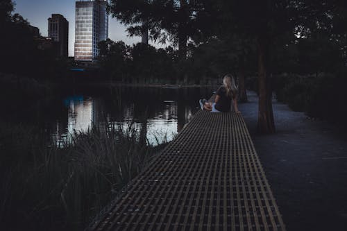 湖の近くに座っている女性の写真