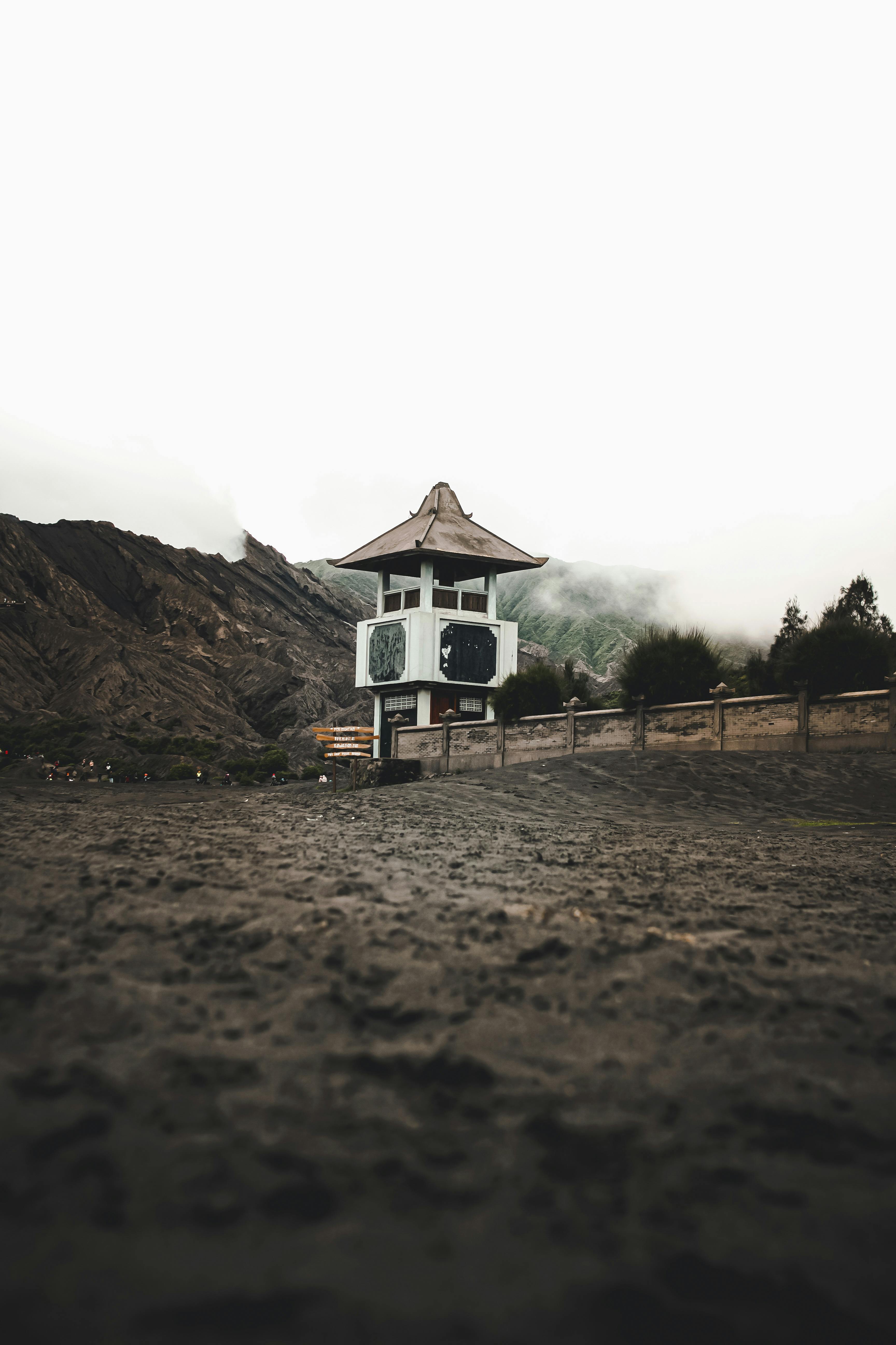 薄雾笼罩的山脉景色宁静，前景的建筑结构独特