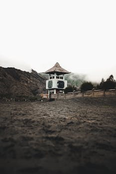 薄雾笼罩的山脉景色宁静，前景的建筑结构独特