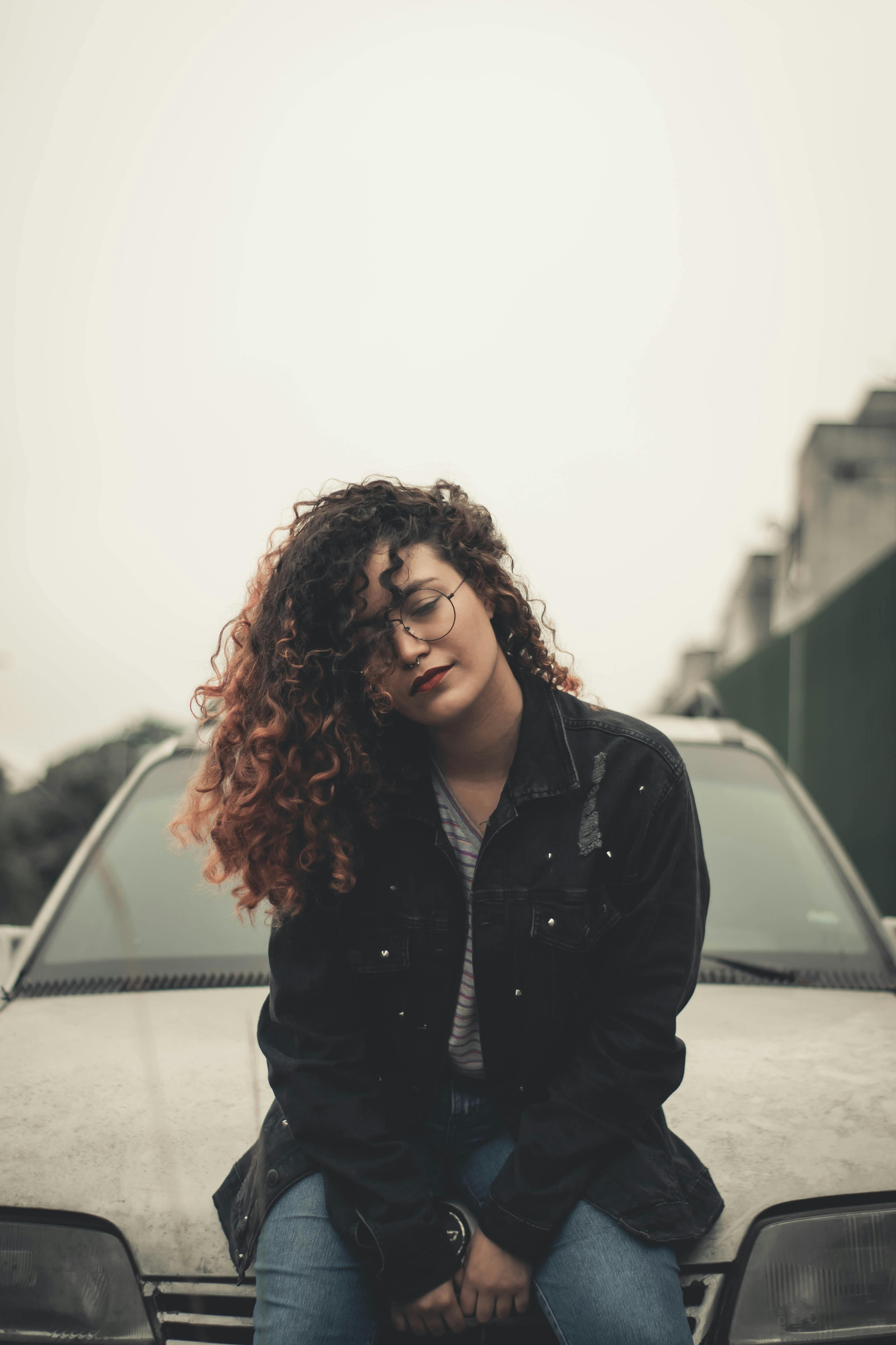 Woman Sitting On The Hood Of A Car