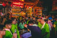 在台湾寺庙，人们聚集在红灯笼下，庆祝传统节日，呈现出一片充满活力的夜景