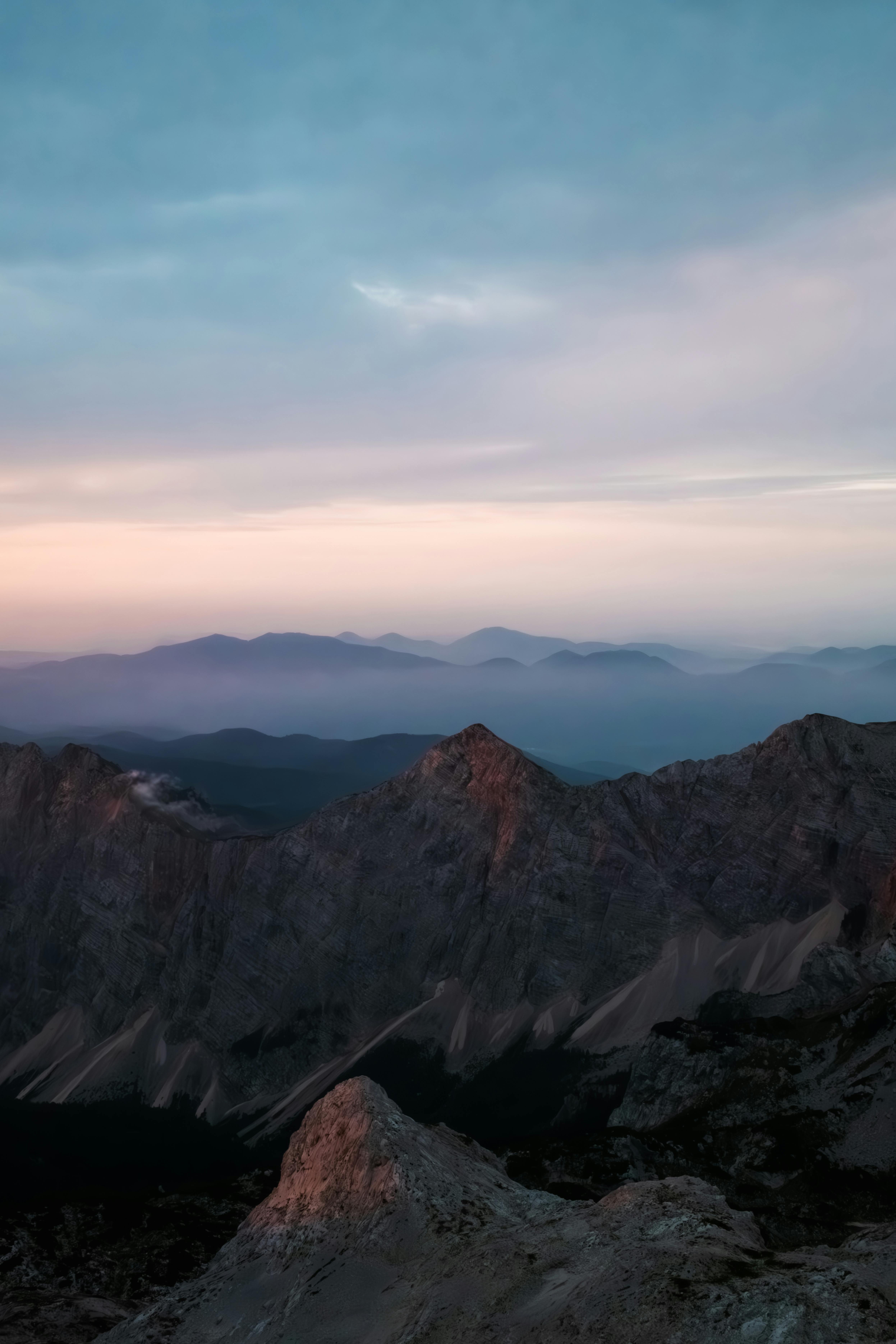 Serene mountain landscape at sunrise in Slovenia with mist and beautiful colors.