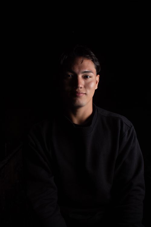 Free Striking portrait of a young man in shadowy lighting, capturing a serious expression. Stock Photo