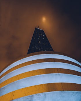 在城市环境中，高耸的摩天大楼以引人注目的视角矗立于戏剧性的夜空下