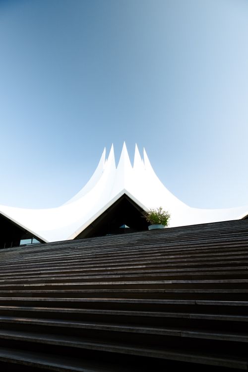 Free Minimalist view of the Tempodrom in Berlin, showcasing its unique roof against a clear blue sky. Stock Photo