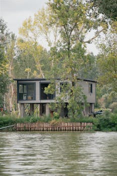 Contemporary house by a serene river surrounded by trees in Hungary.