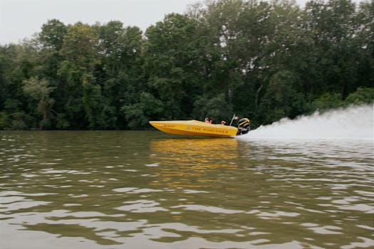 A vibrant yellow speedboat racing on a serene Hungarian river with lush greenery.