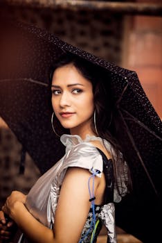 一位美丽的女士手持时尚的黑色雨伞在户外留影，尽显优雅与时尚