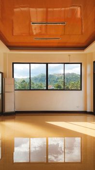 Sunlit empty room with a scenic view overlooking hills in Maasin City, Philippines.