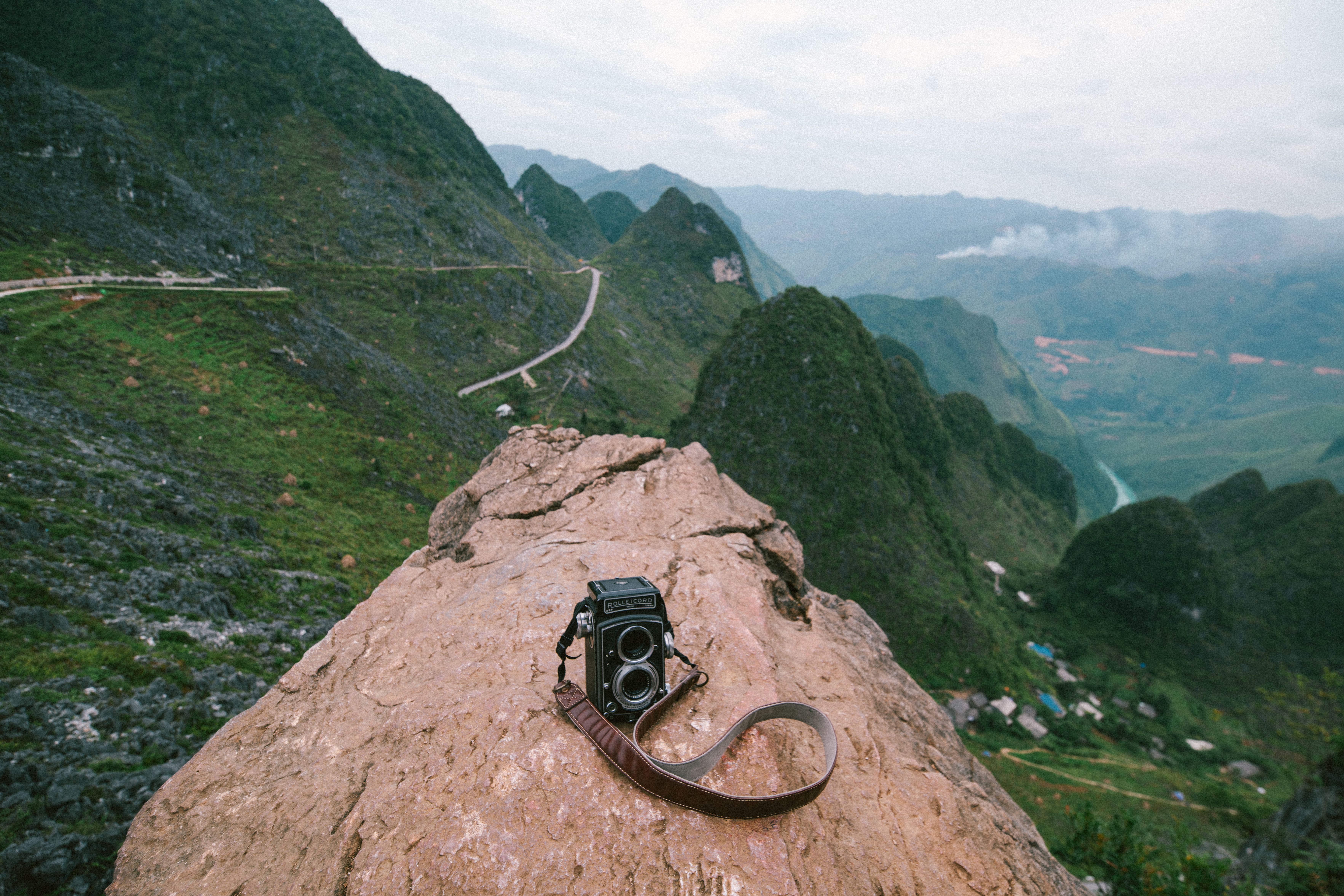 A camera on top of a rock overlooking a valley · Free Stock Photo