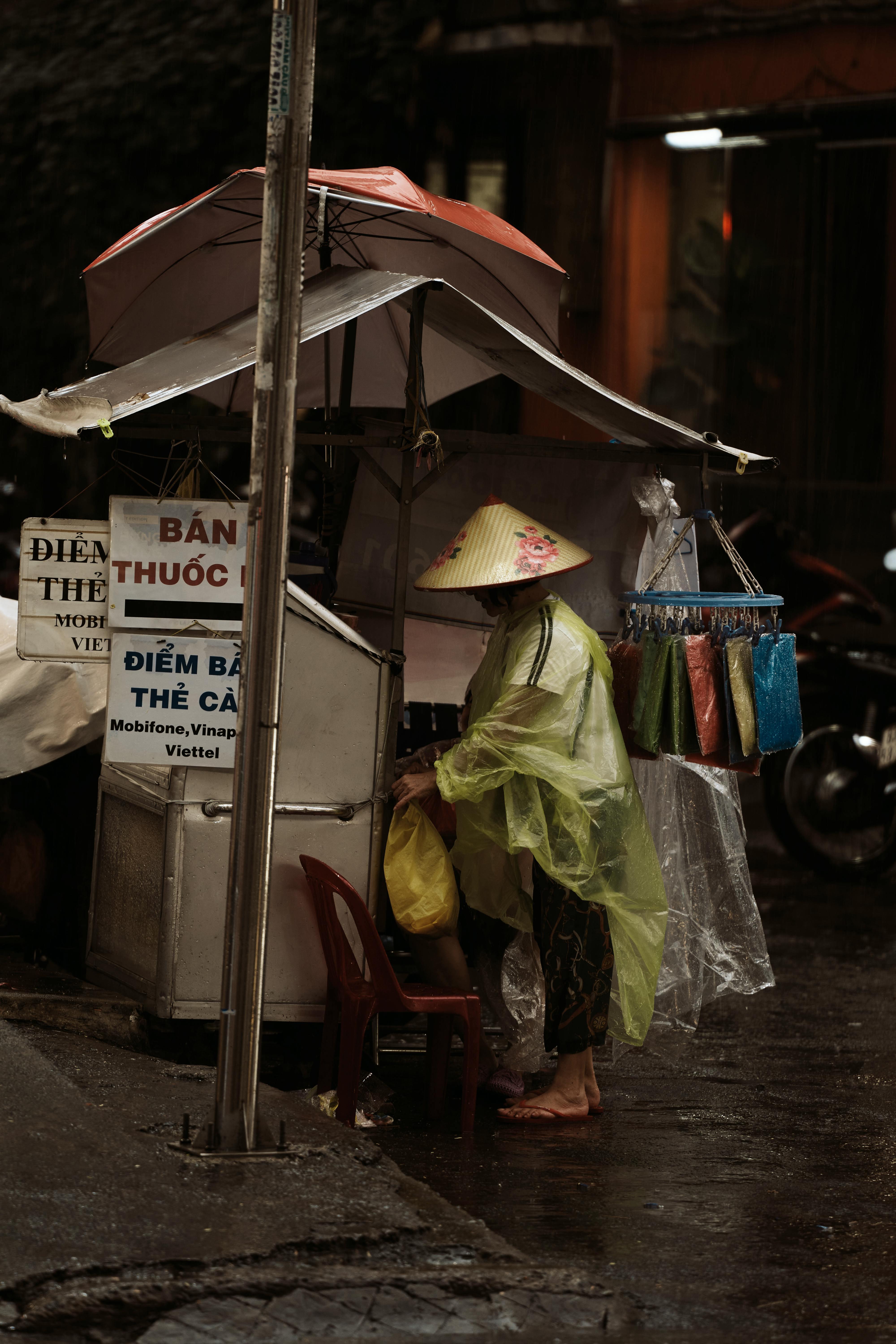 a woman in a yellow raincoat stands in front of a market