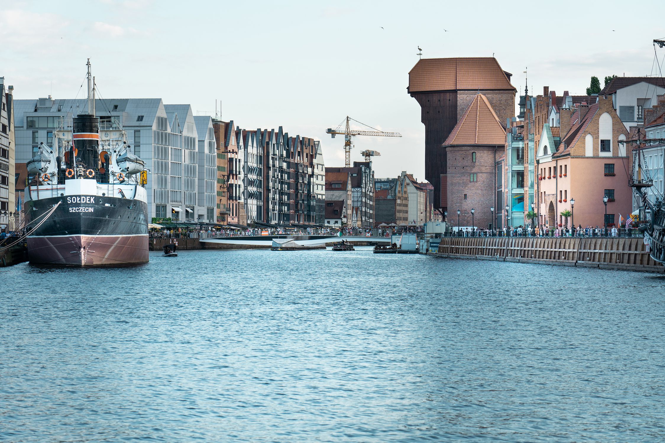 Explore the historic waterfront of Gdansk with iconic architecture and bustling harbor activity.