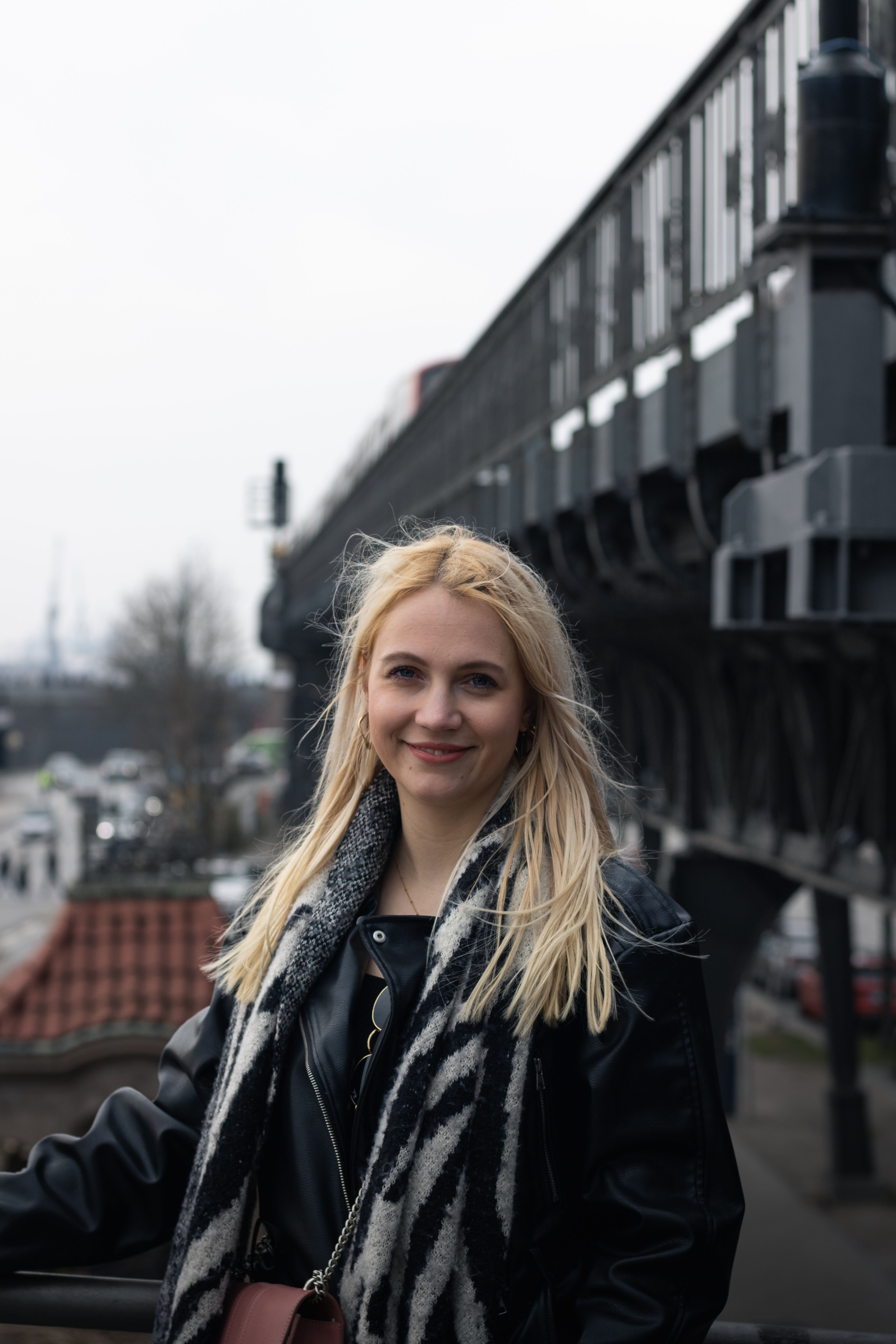 Blonde woman posing confidently outdoors in Hamburg, Germany, showcasing urban fashion.