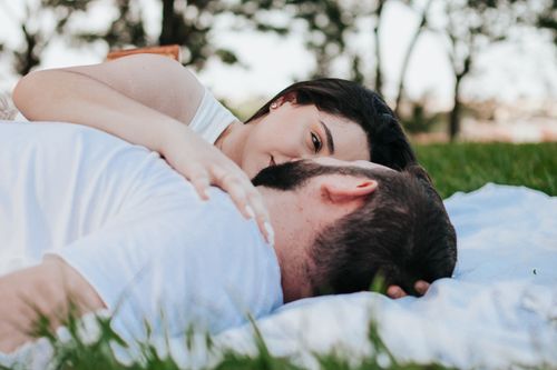 Free A couple relaxing on a picnic blanket outdoors, conveying love and tranquility. Stock Photo