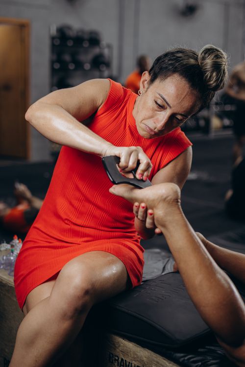 Free Professional foot massage therapy session showing a woman in a red dress massaging a foot. Stock Photo
