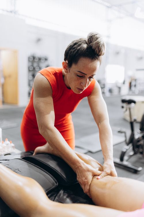 Free A therapist in red performs myofascial release on a client in a gym setting, enhancing recovery. Stock Photo