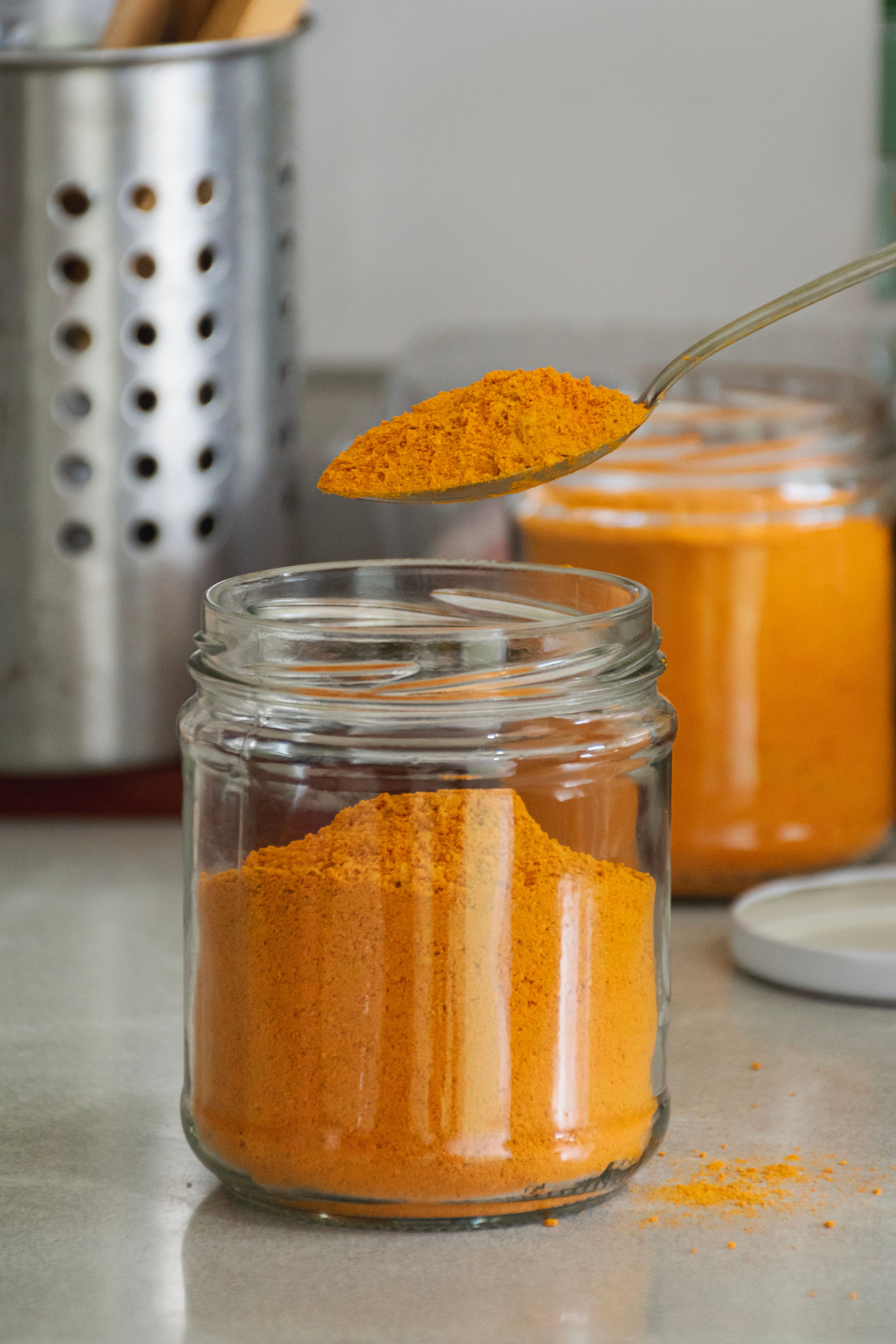 A jar of orange powder with a spoon · Free Stock Photo