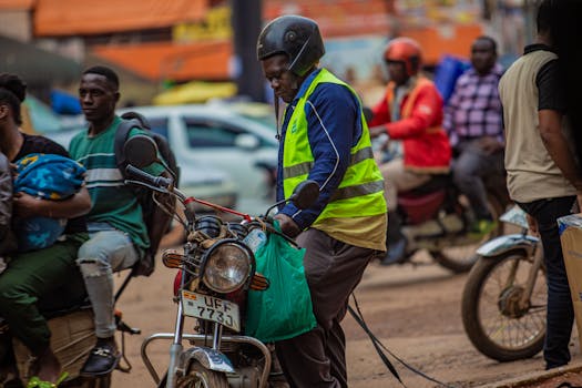 Boda boda riders navigate a bustling city street, showcasing urban transportation dynamics.