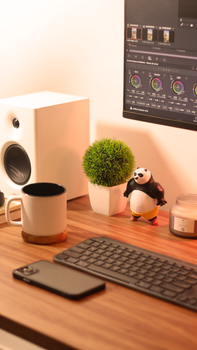 A tidy desk setup featuring gadgets, decor, and a playful panda figurine, perfect for inspiration.