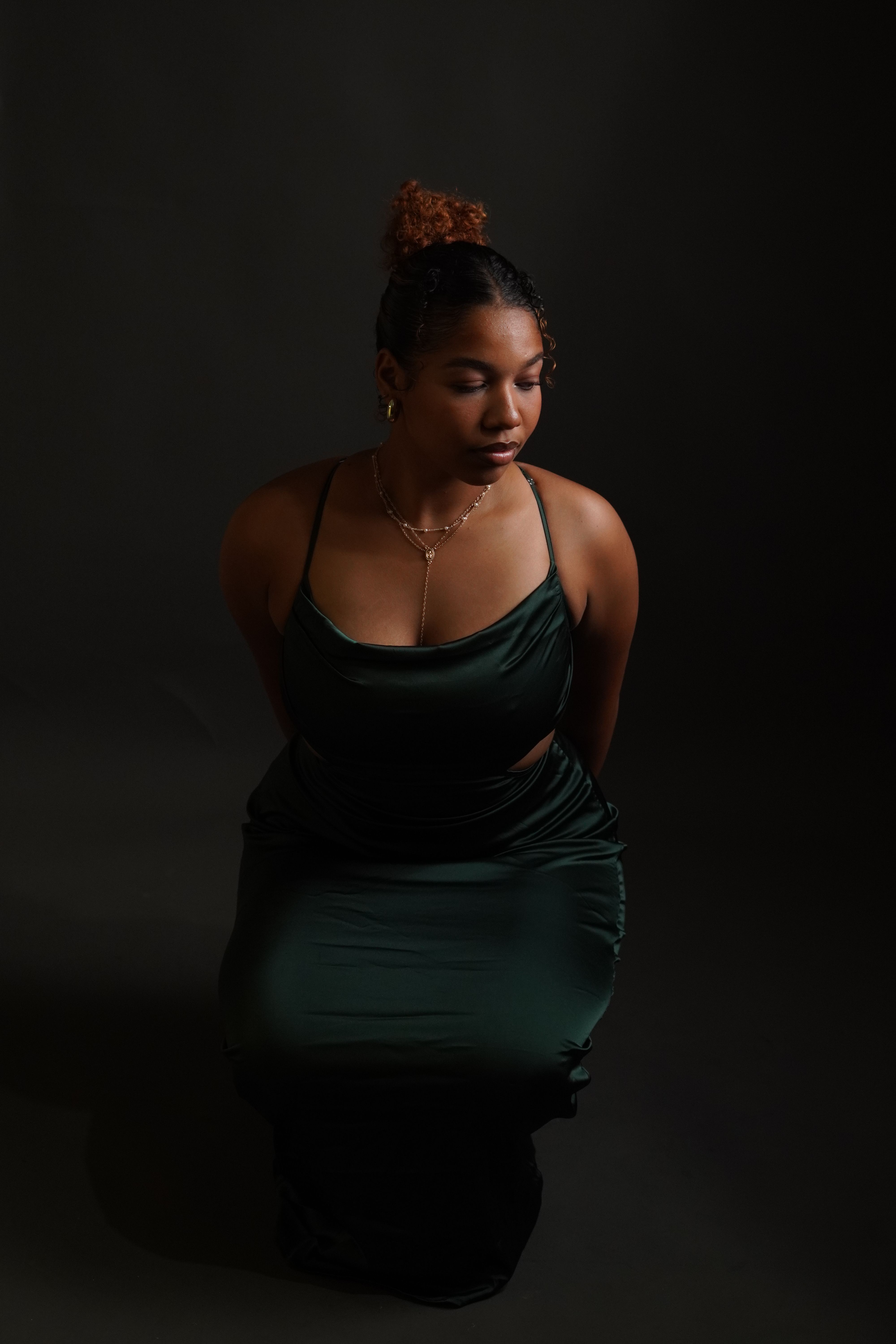 A woman in a green dress sitting on the floor · Free Stock Photo