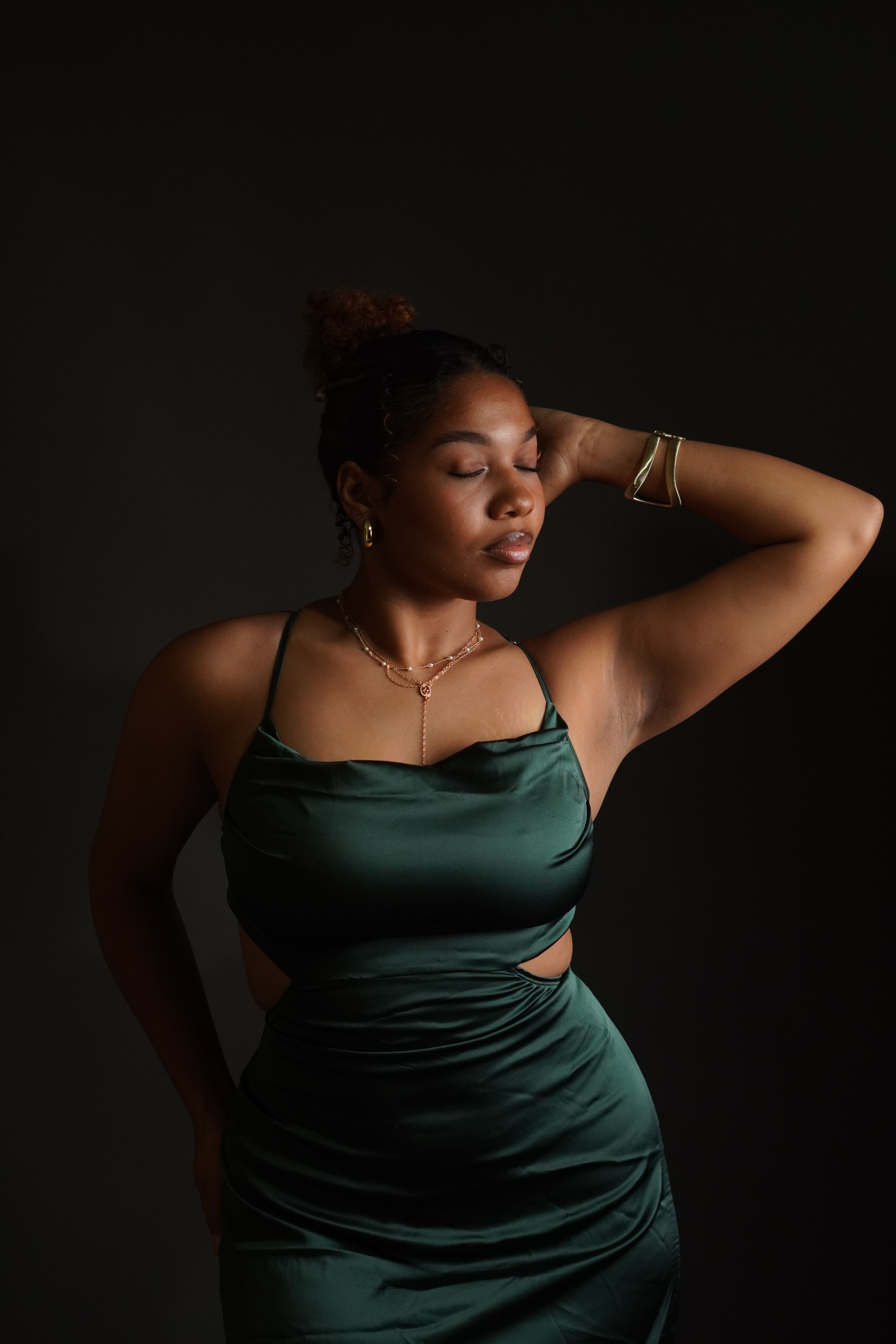 A woman in a green dress poses for a portrait  Free Stock Photo