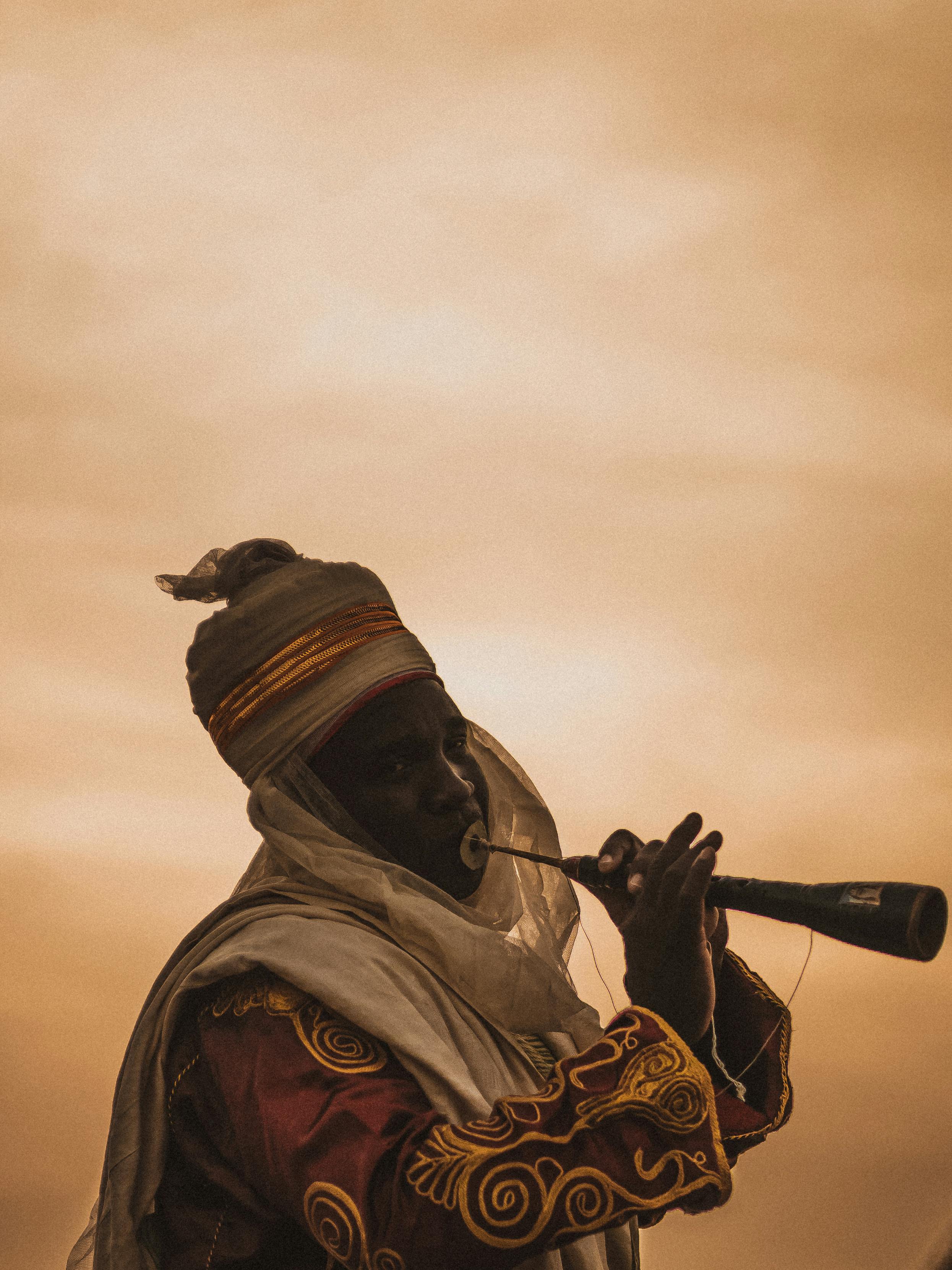 musician in a folk costume playing a traditional algaita