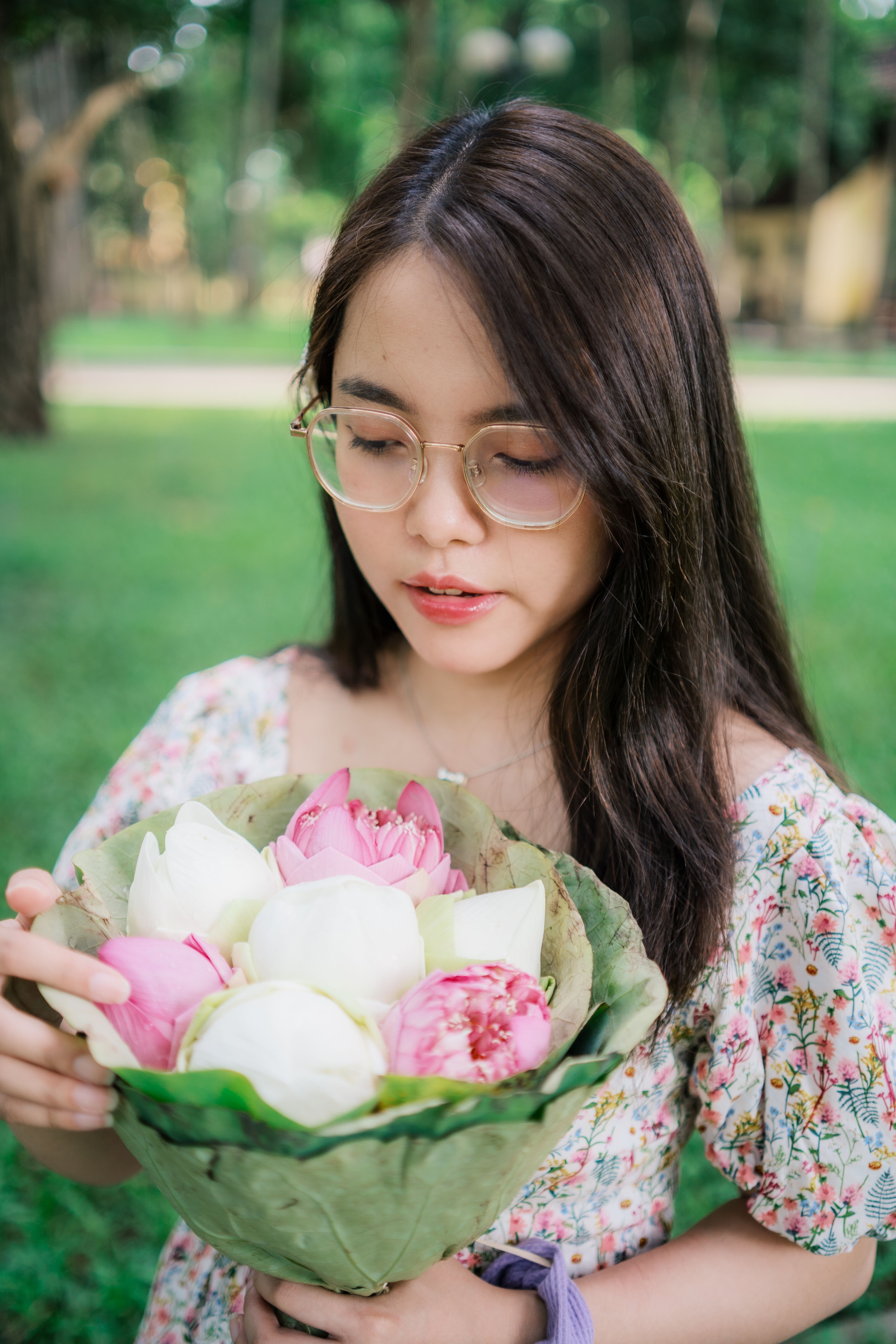 A woman holding a bunch of flowers in her hand · Free Stock Photo