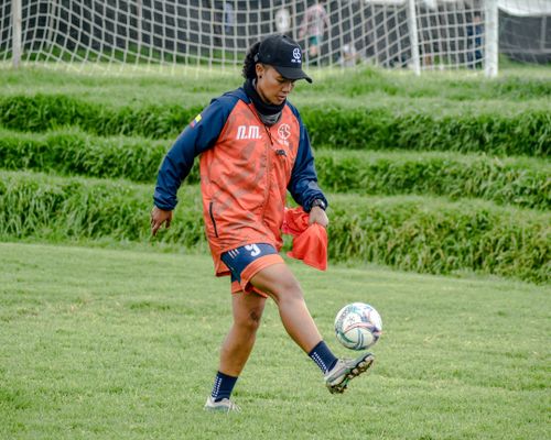 Free A female soccer player in action on a green field, exercising her skills. Stock Photo