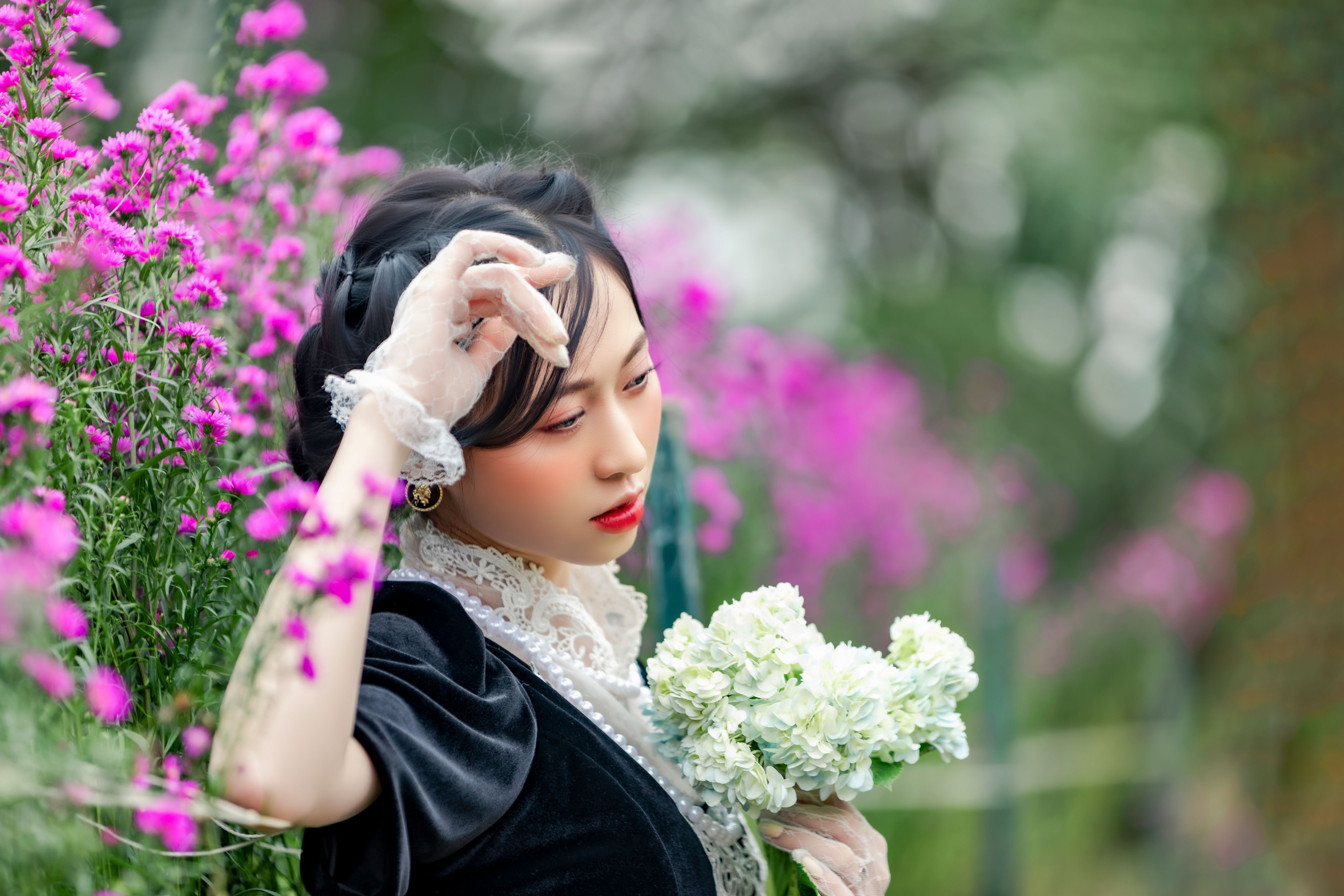 A woman in a black dress holding flowers · Free Stock Photo