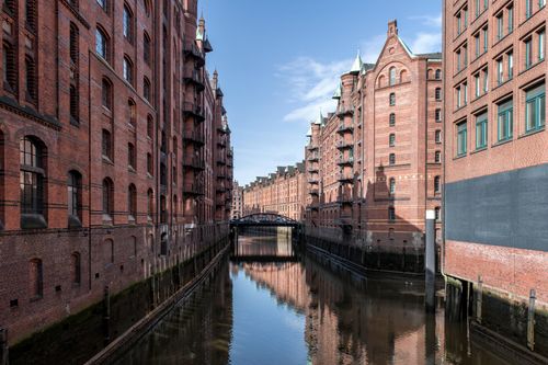 Free Scenic view of Hamburg's historic warehouse district reflecting on canal. Stock Photo