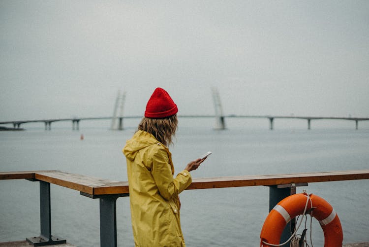 Woman Wearing Yellow Raincoat And Red Beanie