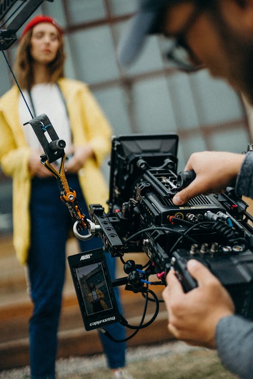 Woman Posing While A Person Is Operating a Camera