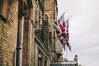 英国牛津一座历史悠久的砖砌建筑在阴天装饰着英国国旗