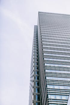 在晴朗的伦敦天空下，现代玻璃摩天大楼呈现出低视角