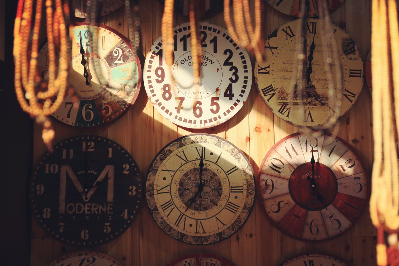 collection of vintage wall clocks with unique designs on a wooden wall