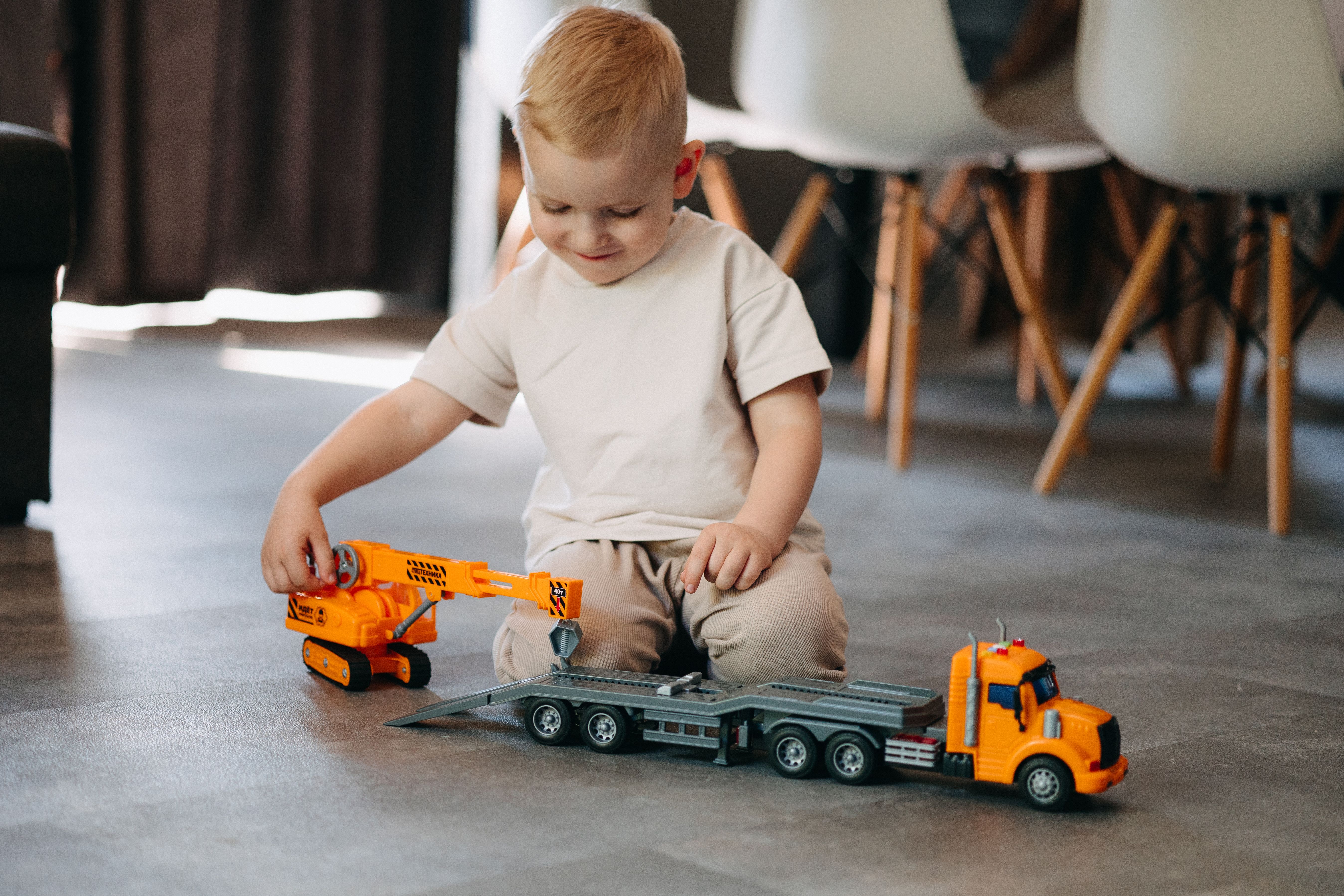 Young boy enjoying playtime with a toy truck inside a cozy home environment.