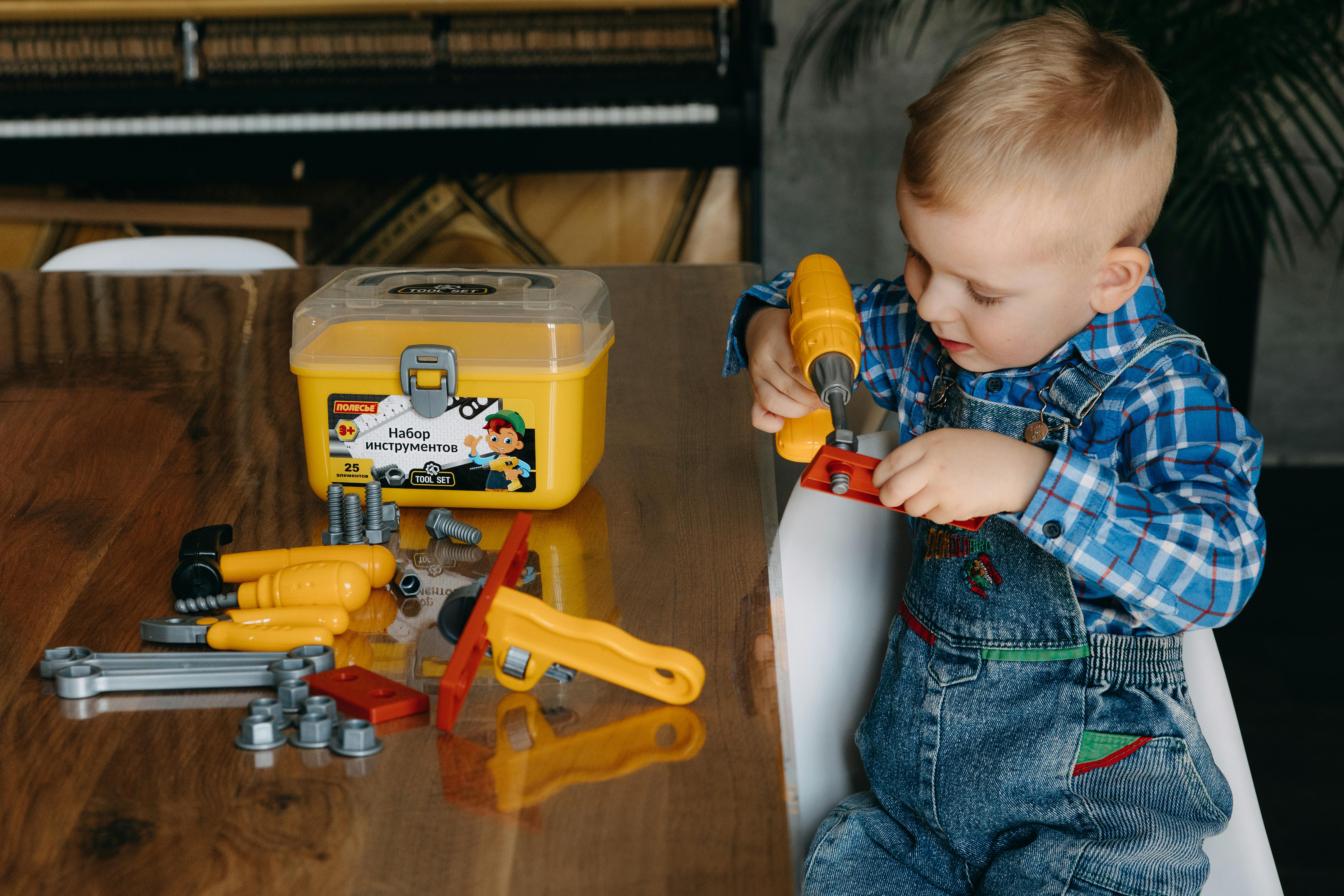 A young boy is playing with a tool set