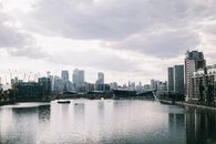英国伦敦的金丝雀码头现代城市景观倒映在河流中，与天际线相映成趣
