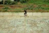 Skateboarder performing a trick in an abandoned urban setting, capturing youthful adventure.
