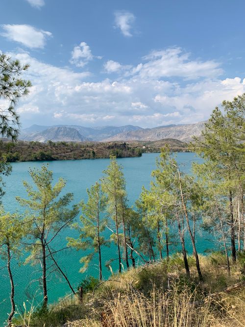 Free A serene landscape of a lake surrounded by mountains and trees, perfect for nature enthusiasts. Stock Photo