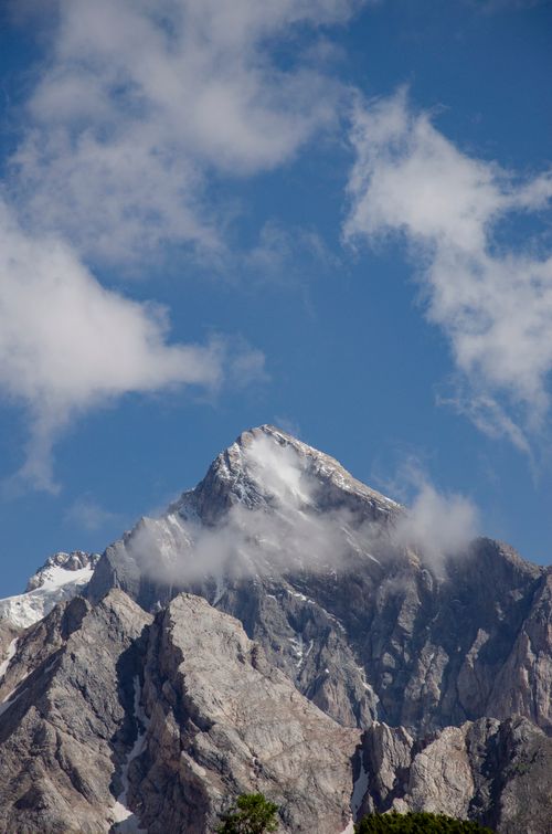 Free A breathtaking view of a snow-capped mountain peak with clouds, showcasing nature's magnificence. Stock Photo