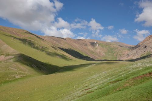 Free Beautiful rolling green hills under a blue sky with clouds in Shymkent, Kazakhstan. Perfect for nature lovers. Stock Photo