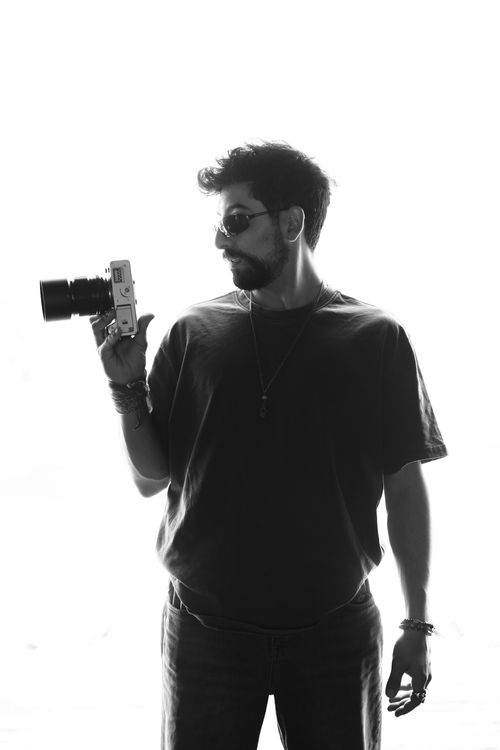 Free Black and white silhouette of a male photographer holding a camera. Stock Photo