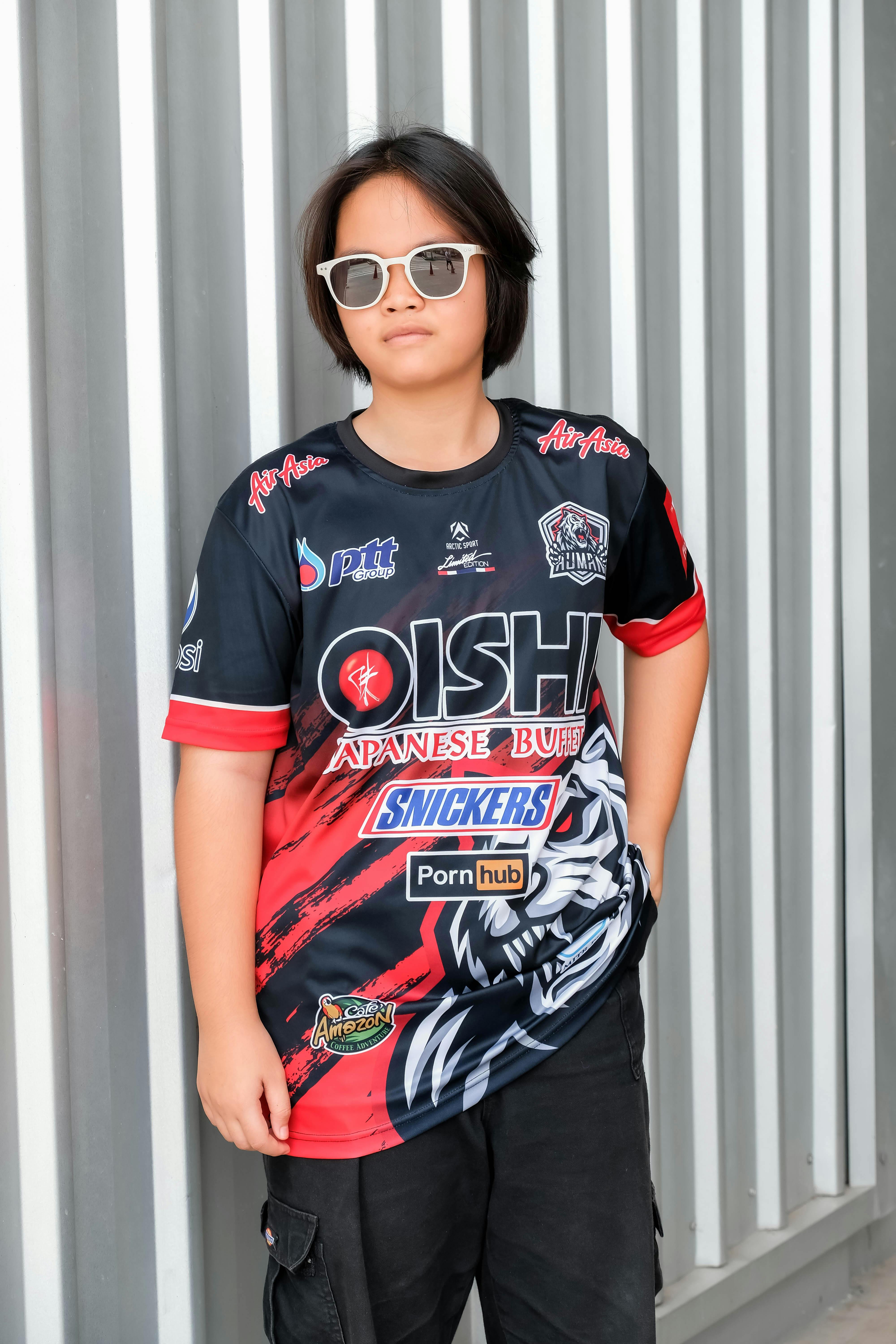 A young boy wearing sunglasses and a motorcycle jersey