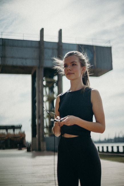 A young woman engaging in outdoor exercise by the port in Sankt-Peterburg, Russia.
