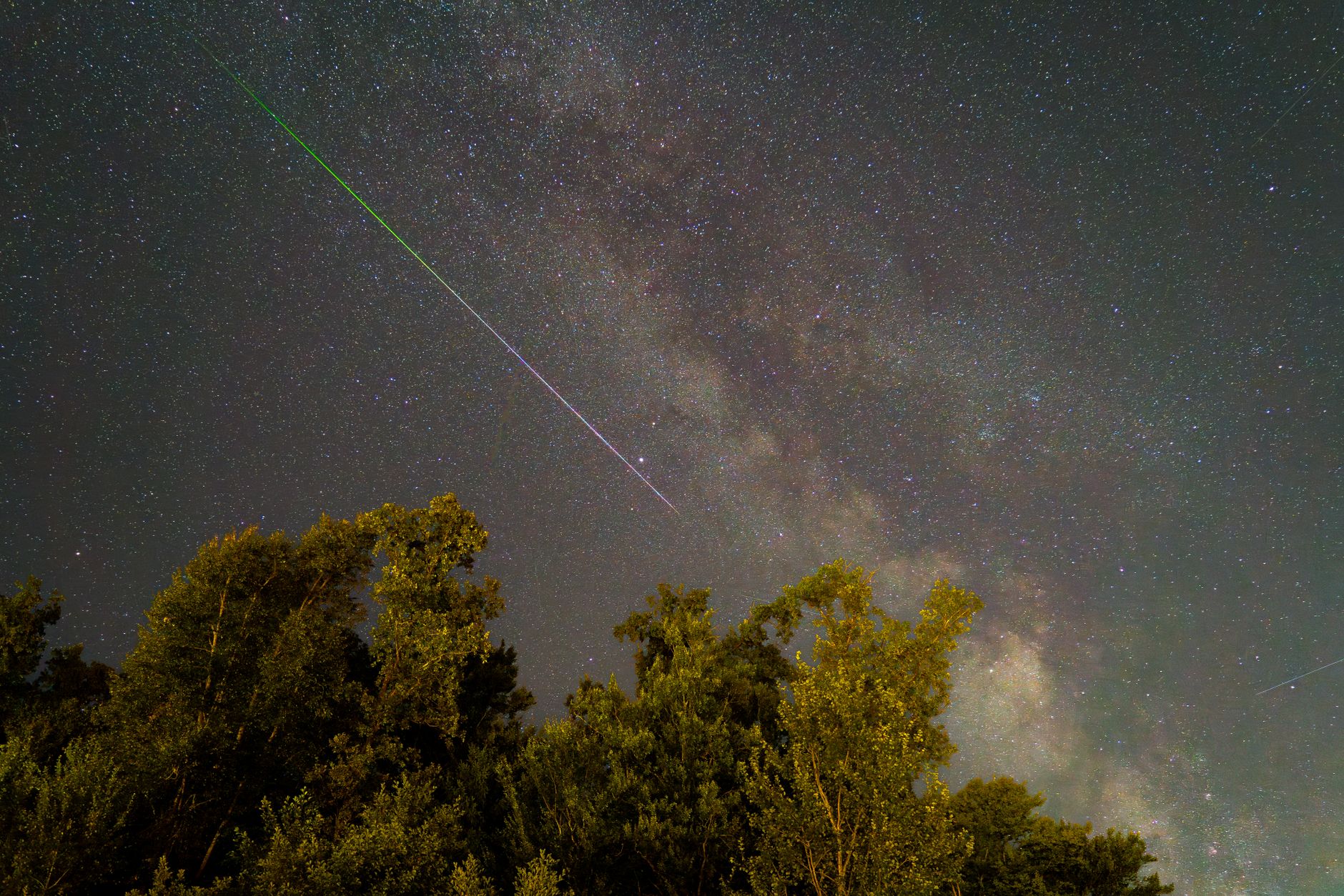 Stunning night sky in Graz, Austria featuring a meteor shower and the Milky Way.