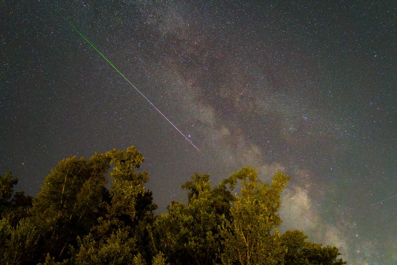 Stunning night sky in Graz, Austria featuring a meteor shower and the Milky Way.